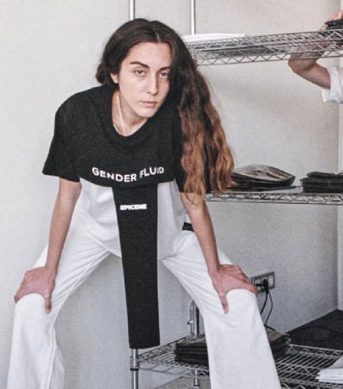 A model in a black t-shirt standing with hands on her thighs