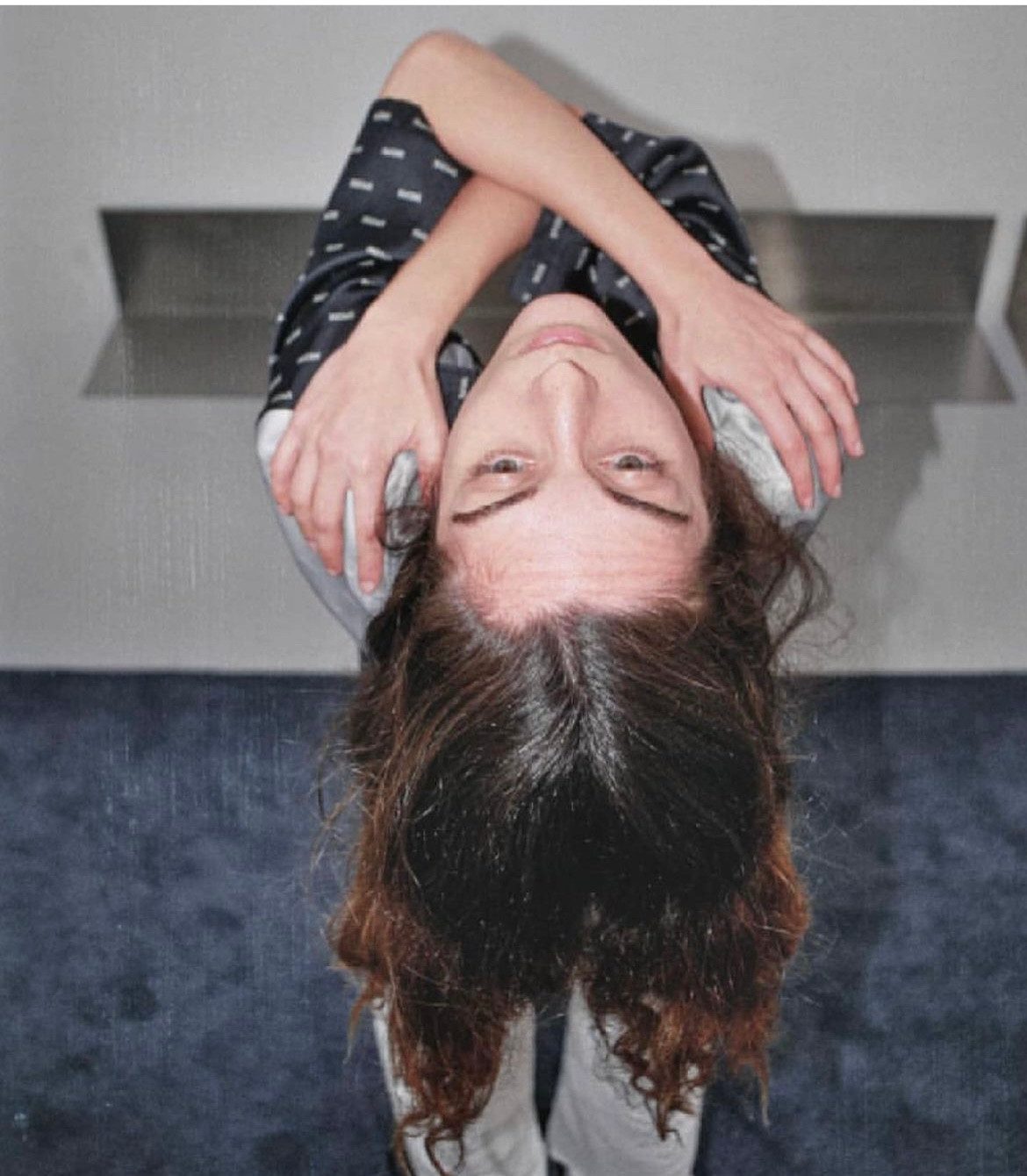 A model hanging upside down with folded arms