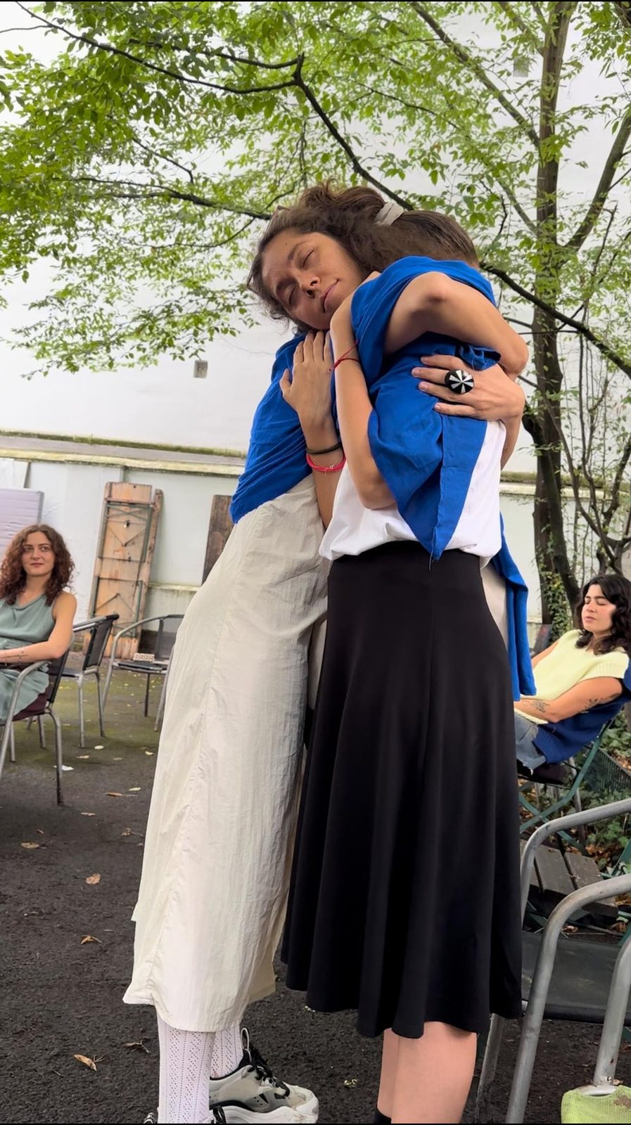 Two performers in a long embrace in the courtyard