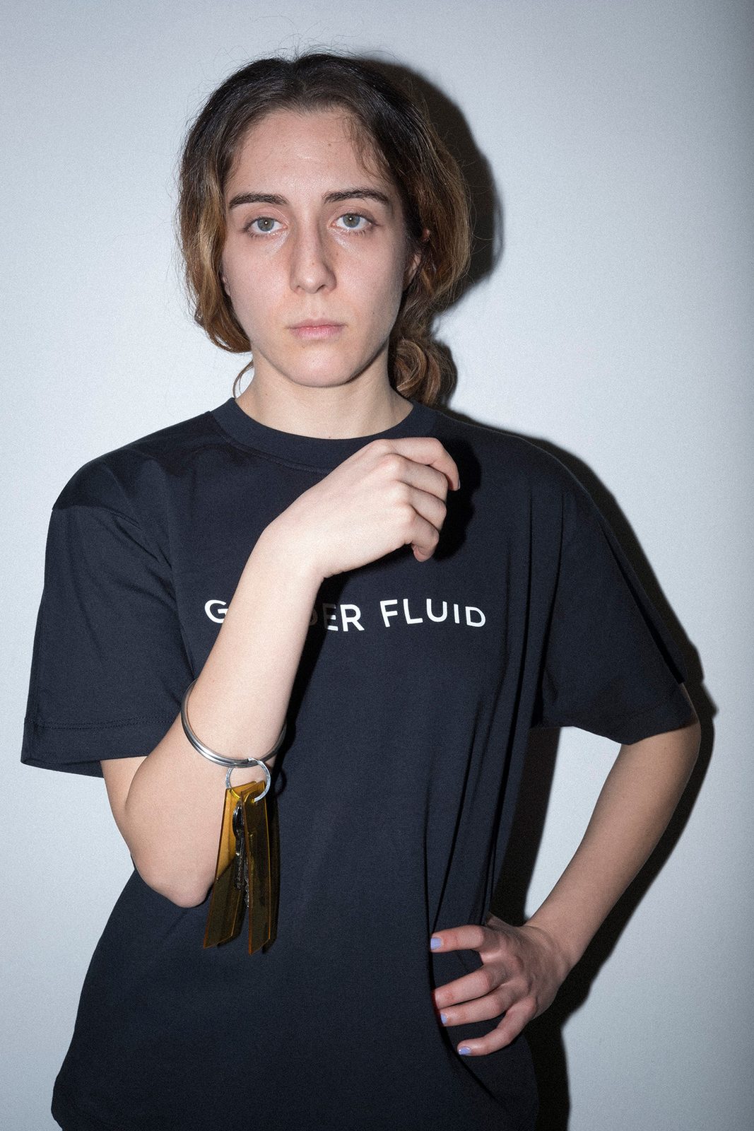 A model in a black Gender Fluid t-shirt with a bracelet of keys